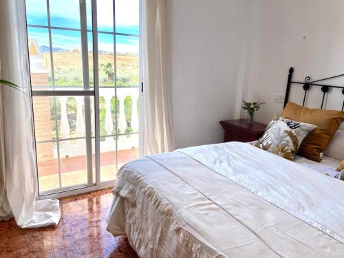 um quarto com uma cama e uma grande janela em Villa Fernando By Solymar Holiday em Málaga