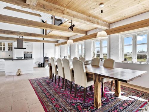 ein Esszimmer mit einem Tisch und Stühlen auf einem Teppich in der Unterkunft Holiday Home Erik - 300m from the sea in Western Jutland by Interhome in Hvide Sande