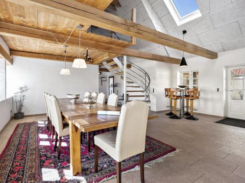 ein Esszimmer mit einem Holztisch und Stühlen in der Unterkunft Holiday Home Erik - 300m from the sea in Western Jutland by Interhome in Hvide Sande