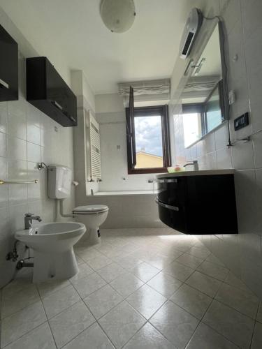 a bathroom with a toilet and a sink and a window at Gramsci suite home in Casa la Luna