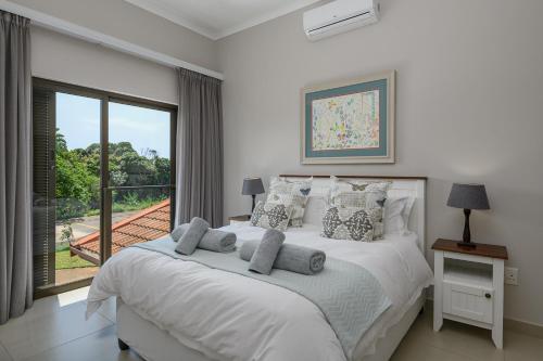 - une chambre avec un lit et une grande fenêtre dans l'établissement San Lameer Villa 14321 - 5 Bedroom Deluxe - 10 pax - San Lameer Rental Agency, à Southbroom
