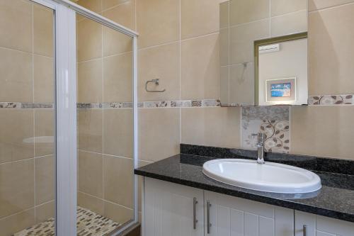 uma casa de banho com um lavatório e um chuveiro em San Lameer Villa 14321 - 5 Bedroom Deluxe - 10 pax - San Lameer Rental Agency em Southbroom