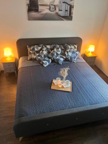a bed with a tray with two candles on it at Ferienhaus Bella Haus am Harkebrügger See in Barßel