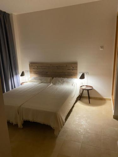 Un dormitorio con una gran cama blanca y una mesa en Sonne - Golf - 4Pers. - Apartments, en Fuente-Álamo de Murcia