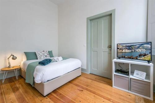 Schlafzimmer mit einem Bett und einem Flachbild-TV in der Unterkunft In Lapa Studio I in Porto