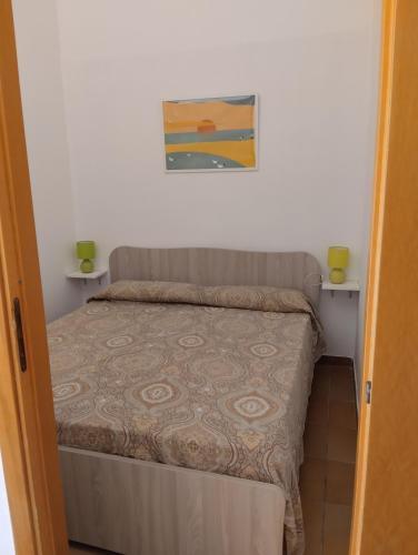 a small bedroom with a bed and a painting on the wall at Casa di Sole in Cariati