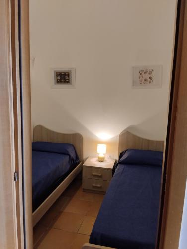 Cette petite chambre comprend deux lits et une lampe sur une table. dans l'établissement Casa di Sole, à Cariati