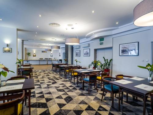 a restaurant with tables and chairs in a room at Mercure Czestochowa Centrum in Częstochowa
