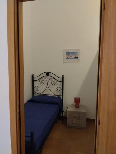 a small bedroom with a bed with a blue bedspread at Casa di Sole in Cariati