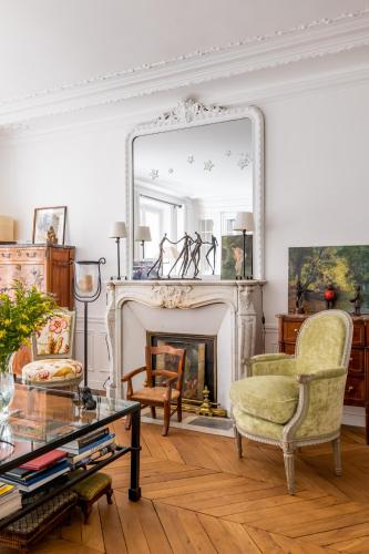 un salon avec une cheminée et un miroir dans l'établissement Veeve - Fresh as a Daisy, à Paris