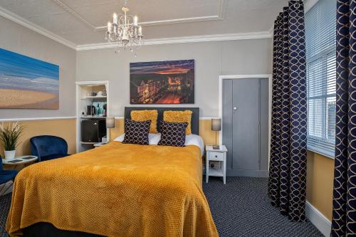 a bedroom with a bed with a yellow blanket at Glenholme Guest House - Room Only in Scarborough