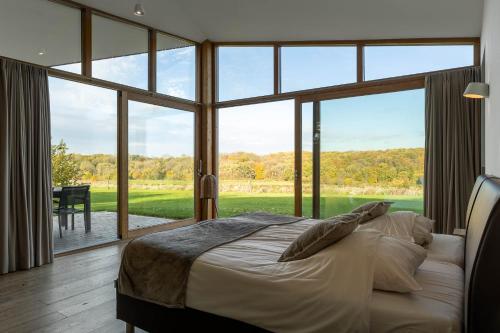 een slaapkamer met een bed en een groot raam bij Landgoed Moerslag in Sint Geertruid