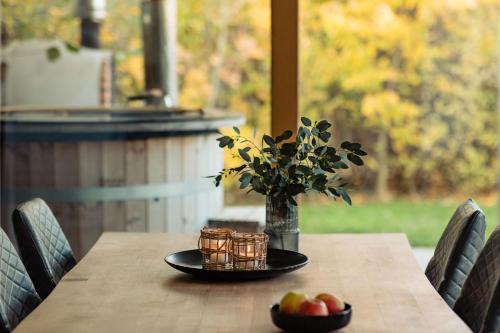 a table with a plate of fruit and a vase of flowers at Landgoed Moerslag in Sint Geertruid