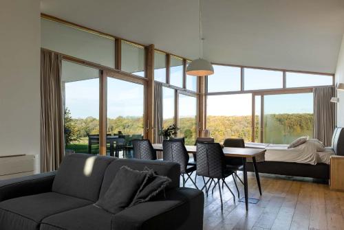 a living room with a couch and a table with chairs at Landgoed Moerslag in Sint Geertruid