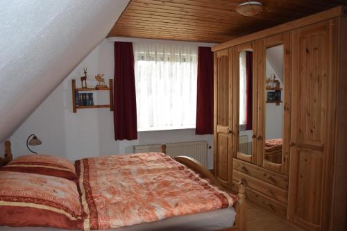 a bedroom with a bed and a wooden cabinet at Ferienwohnung Möwennest in Elmenhorst