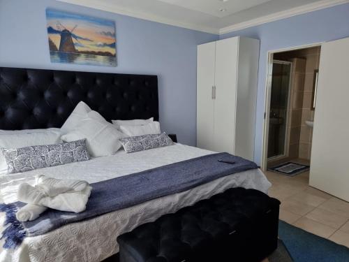 a bedroom with a large bed with a black headboard at Danrit Guesthouse - Uncapped wifi in Roodepoort