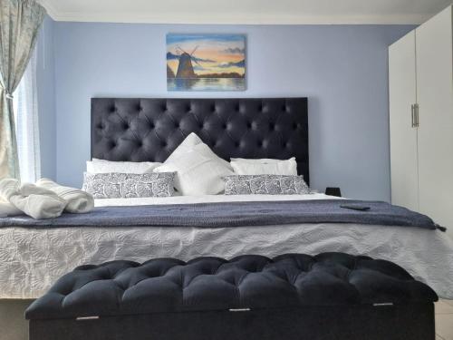 a bedroom with a large bed with a black headboard at Danrit Guesthouse - Uncapped wifi in Roodepoort