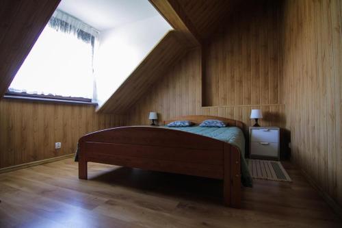 Chalupa Dejnowo في Pilec: غرفة نوم بسرير ونافذة كبيرة
