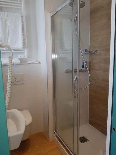 a shower with a glass door in a bathroom at Les Chants d'Ailes - Hôtel Face Mer in La Turballe
