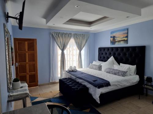 Un dormitorio con una cama grande y una ventana en Danrit Guesthouse - Uncapped wifi en Roodepoort