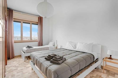 een witte slaapkamer met een groot bed en een raam bij CAV9 - Large Apartment with Panoramic VIEW - in Milaan