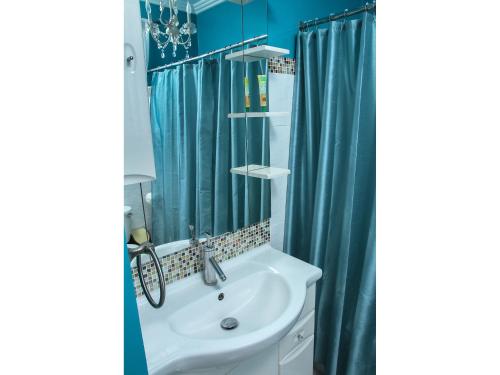 bagno con lavandino e tenda doccia blu di Zenbreak Bliss Twin Bedroom a Bridgetown
