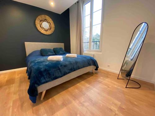 een slaapkamer met een bed en een spiegel aan de muur bij 02 Appart cozy à 5min de Fontainebleau in Bourron-Marlotte
