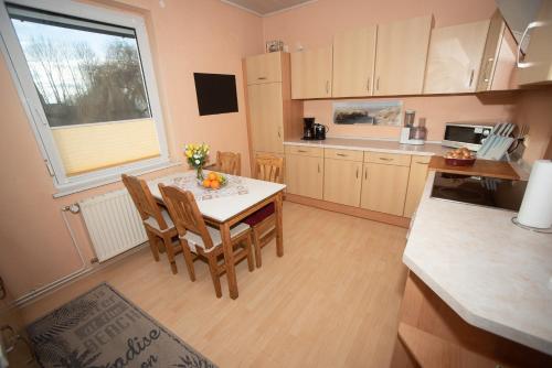 a kitchen with a table and chairs and a window at Ferienwohnung in Bitterfeld-Wolfen in Große Mühle