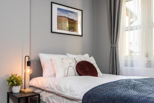 a bedroom with a white bed and a window at Felicjanek 15 - by Upstairs in Krakow