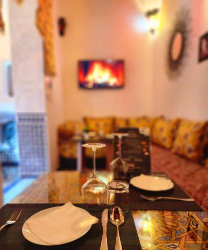 a table with plates and silverware on top of it at Riad Dar Kassim in Fès