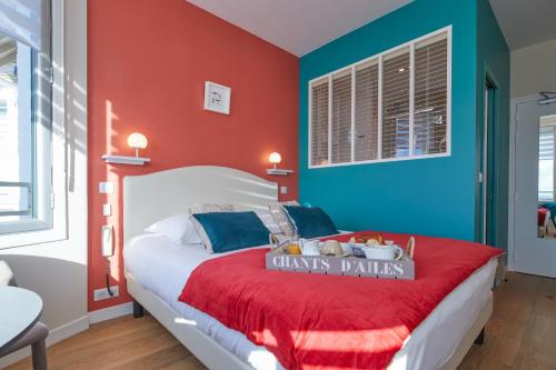 a bedroom with a bed with red and blue walls at Les Chants d'Ailes - Hôtel Face Mer in La Turballe