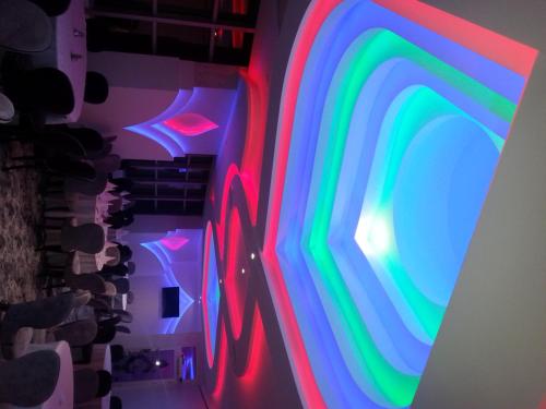 a room with colorful lights on the wall at Hotel Ženeva Lux in Kragujevac