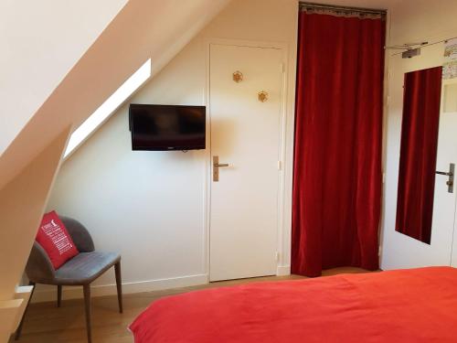 a bedroom with a bed and a red curtain at Les Chants d'Ailes - Hôtel Face Mer in La Turballe