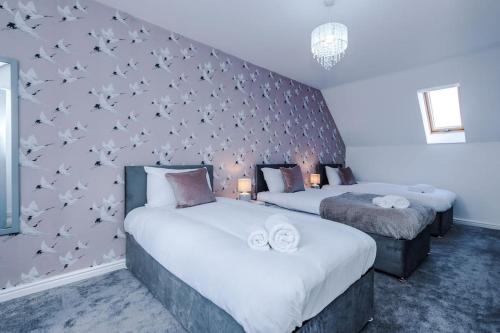 een slaapkamer met 2 bedden en een muur met vogels erop bij Lovely three bed home Manchester in Heywood