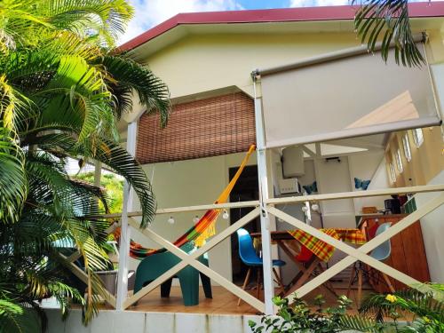 a house with a balcony with a sliding glass door at Gîte Ti Papiyon in Bouillante