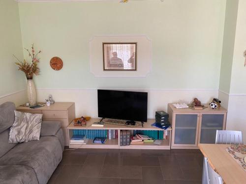 een woonkamer met een bank en een flatscreen-tv bij Casa Vacanze Rinaldi in Mattinata