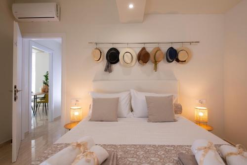 a bedroom with a bed with hats hanging on the wall at Creta Vivere Villas in Agia Pelagia