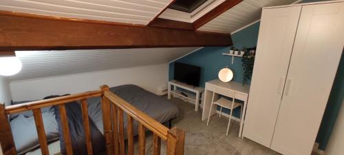 a bedroom with a bed and a desk in a room at Studette Rémoise in Reims