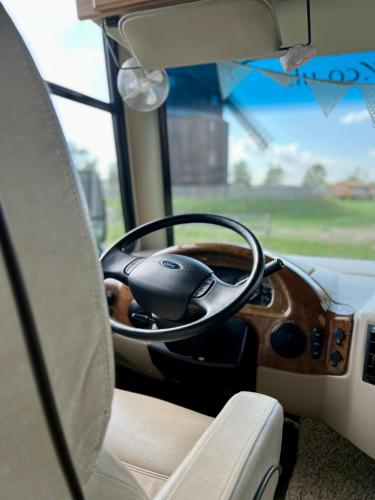a dashboard of a bus with a steering wheel at Camper XXL in Parey