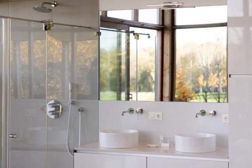 a bathroom with two sinks and a shower at Landgoed Moerslag in Sint Geertruid