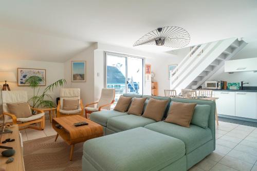 un salon avec un canapé bleu et une cuisine dans l'établissement Penn Odet - vue mer, à Bénodet