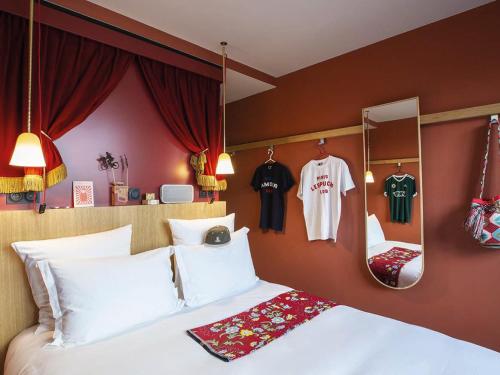 a bedroom with a bed and jerseys hanging on the wall at MOB HOTEL Paris Les Puces in Saint-Ouen
