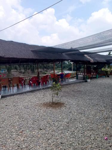 ein kleiner Baum vor einem Gebäude mit Tischen und Stühlen in der Unterkunft Pondok orange FIFA almahera in Binjai