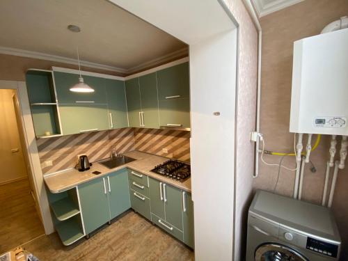una cocina con armarios verdes y fregadero en APARTMENT in TBILISI Koko en Tiflis