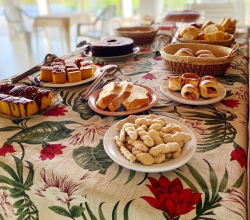 卡皮托利乌Suítes Canaã的一张桌子,上面放着糕点和馅饼