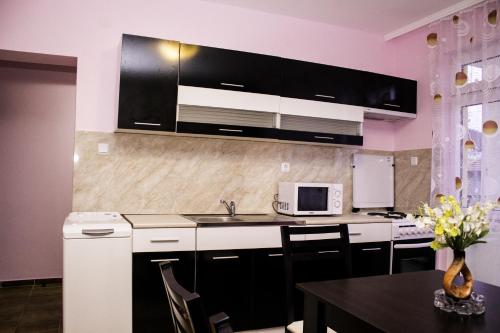 a kitchen with black and white cabinets and a table at ,,Дироси'' in Sveti Vlas