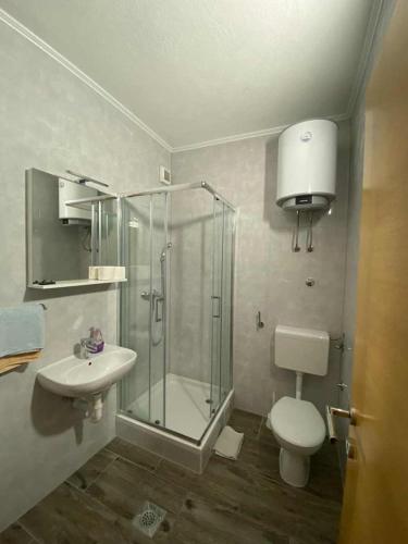 a bathroom with a shower and a toilet and a sink at Apartmani Babić in Neum