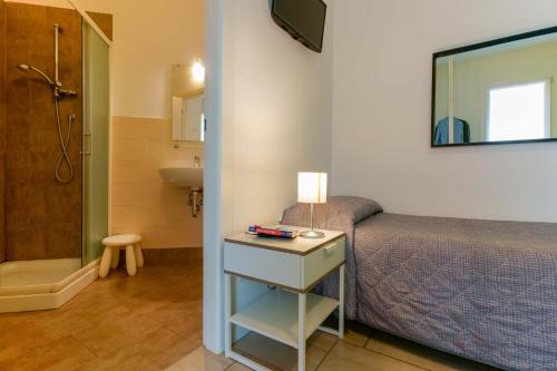 um quarto com uma cama e uma casa de banho com um chuveiro em B&B Bentivogli em Bolonha