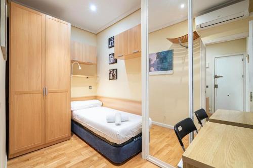 mały pokój z łóżkiem i szklanymi drzwiami w obiekcie Tranquilo apartamento Pacífico/Ciudad de Barcelona w Madrycie