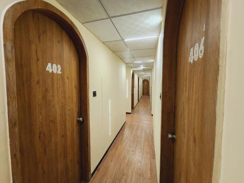 a hallway of an office with two doors and wood floors at Hotel Nova Bopal in Bodakdev